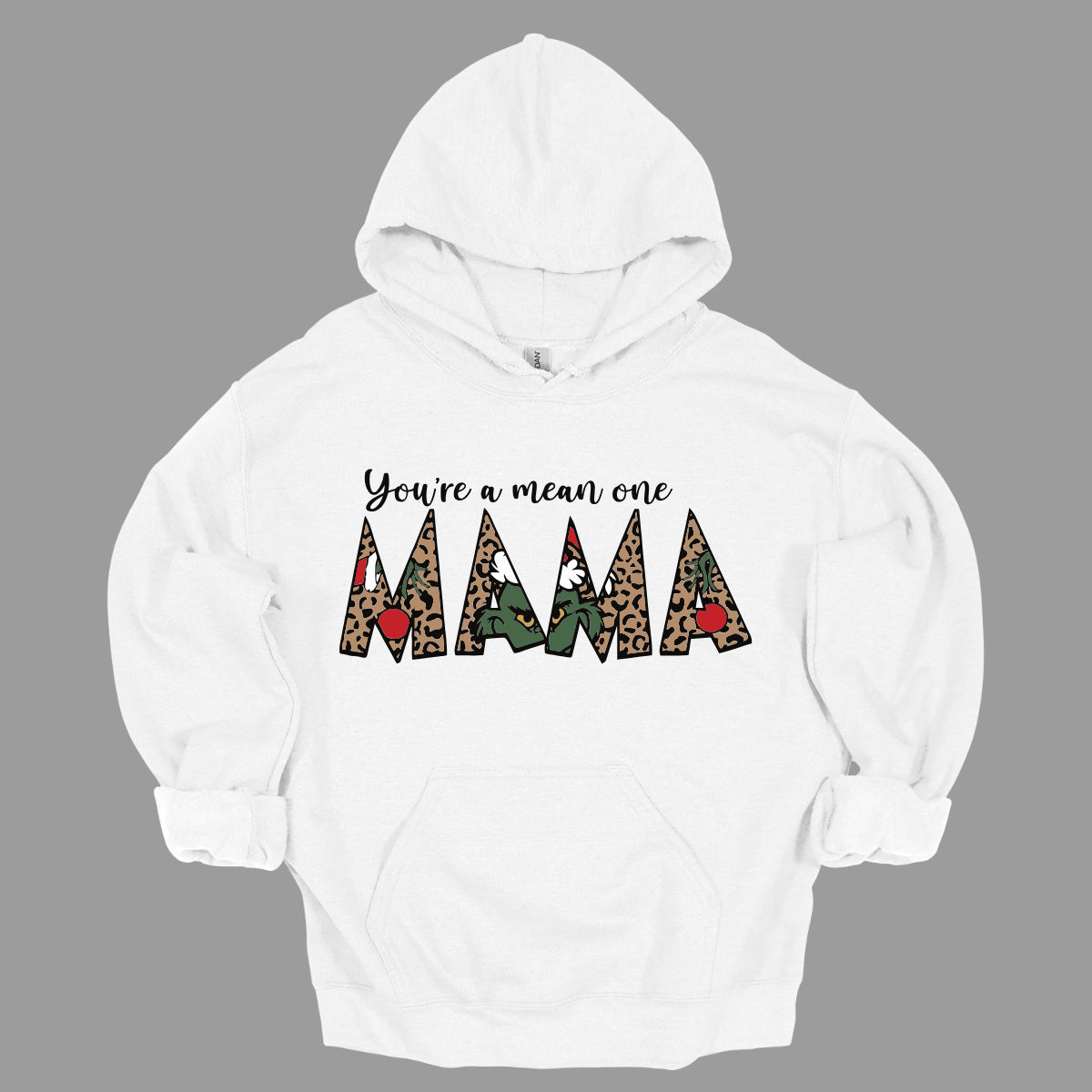 The phrase "You're a Mean One Mama" takes center stage, with "You're a Mean One" written in elegant black cursive font that flows beautifully across the fabric. The standout element is the word "Mama," which is rendered in bold, eye-catching letters. Each letter of "Mama" is filled with a quirky depiction of the Grinch, set against a vibrant cheetah print background. Shop Gorgeousware.com