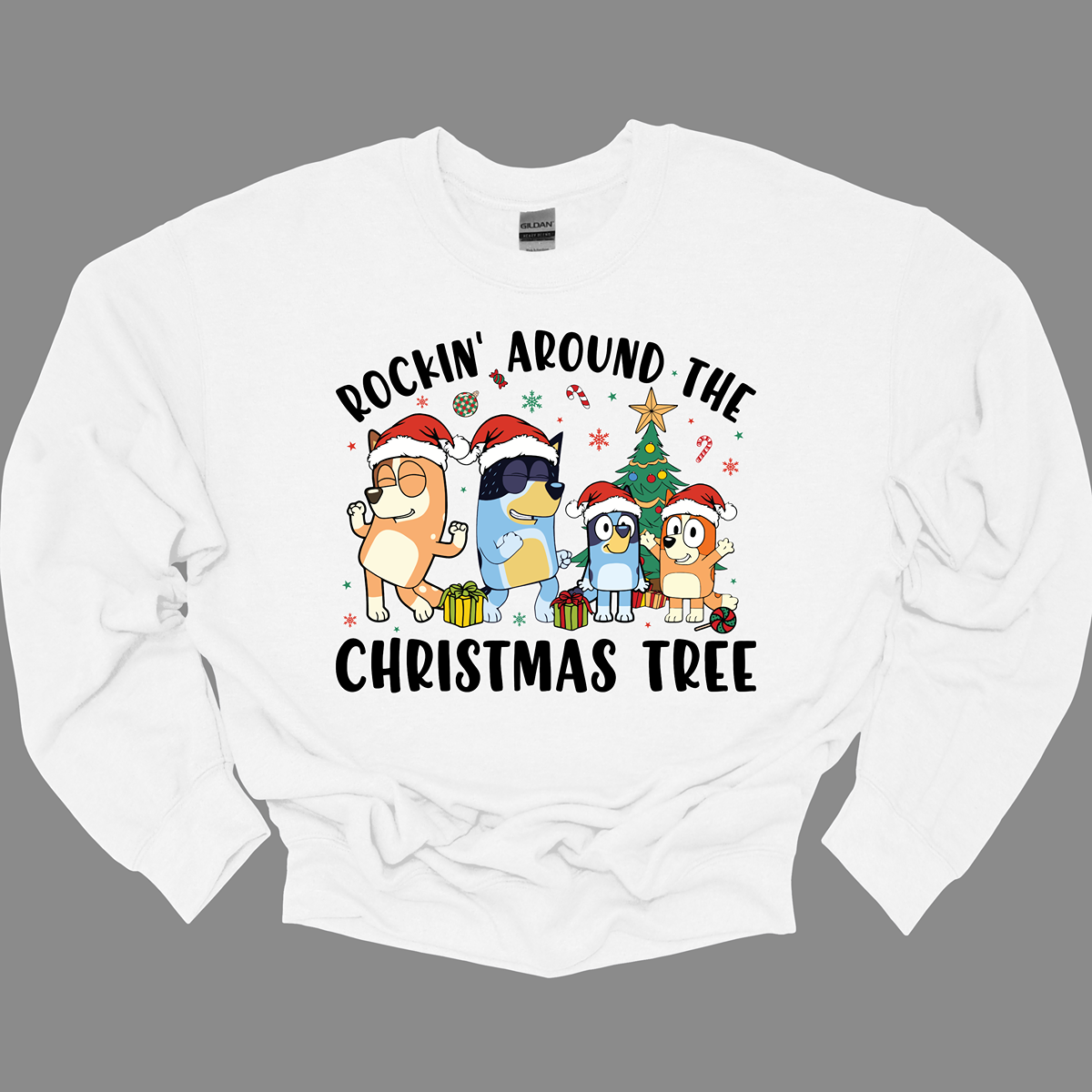 Celebrate the festive season with Bluey and her family in this heartwarming design! The beloved Bluey and her family are gathered around a beautifully decorated Christmas tree, joyfully rocking around the holiday cheer. The playful scene is filled with bright colors, festive ornaments, twinkling lights, and the spirit of togetherness. The phrase "Rockin' Around the Christmas Tree" arches over the design, capturing the fun and excitement of the holidays.