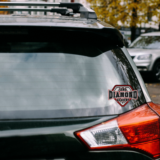 Car with a roof rack and 'Diamond Academy' sticker in an urban setting