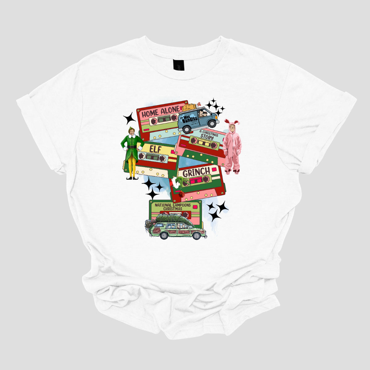 This design t-shirt showcases a nostalgic tribute to classic Christmas movies with a vibrant design featuring beloved characters. Each movie is represented by a unique cartoon illustration Home Alone, A Christmas Story, Elf, The Grinch, and Christmas Vacation. The colorful illustrations are framed by cassette tapes, adding a retro touch that evokes warm memories of holiday movie marathons. Shop Gorgeousware.com