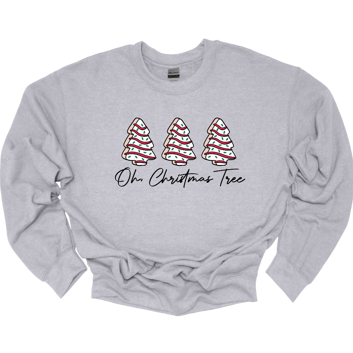 This t-shirt features a whimsical holiday design that’s perfect for spreading cheer. The shirt is adorned with the phrase “Oh Christmas Tree” written in elegant black cursive font, adding a touch of sophistication to the festive message. Above the words, three iconic Christmas tree snack cakes are illustrated, each depicted with their classic, playful decorations. Shop Gorgeousware.com