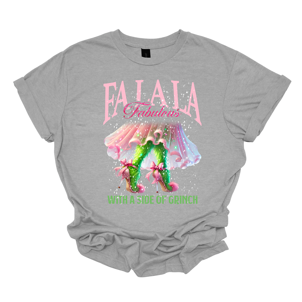 The design features a playful and festive take on the Grinch character with a stylish twist. The phrase "Fa La La Fabulous" is at the top in a fun, cursive font with a bouncy, holiday-inspired feel. The word "Fabulous" stands out in bold, glamorous lettering with subtle sparkles, giving it a chic vibe. Below, the Grinch is shown with her girly green legs, styled in light pink high heels adorned with oversized bows at the back, adding a sweet and fashionable touch. Shop at Gorgeousware.com