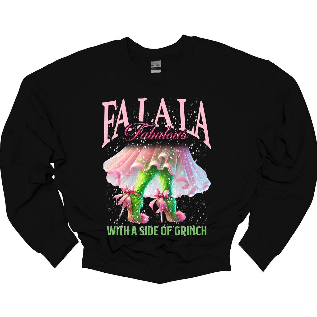 The design features a playful and festive take on the Grinch character with a stylish twist. The phrase "Fa La La Fabulous" is at the top in a fun, cursive font with a bouncy, holiday-inspired feel. The word "Fabulous" stands out in bold, glamorous lettering with subtle sparkles, giving it a chic vibe. Below, the Grinch is shown with her girly green legs, styled in light pink high heels adorned with oversized bows at the back, adding a sweet and fashionable touch. Shop at Gorgeousware.com