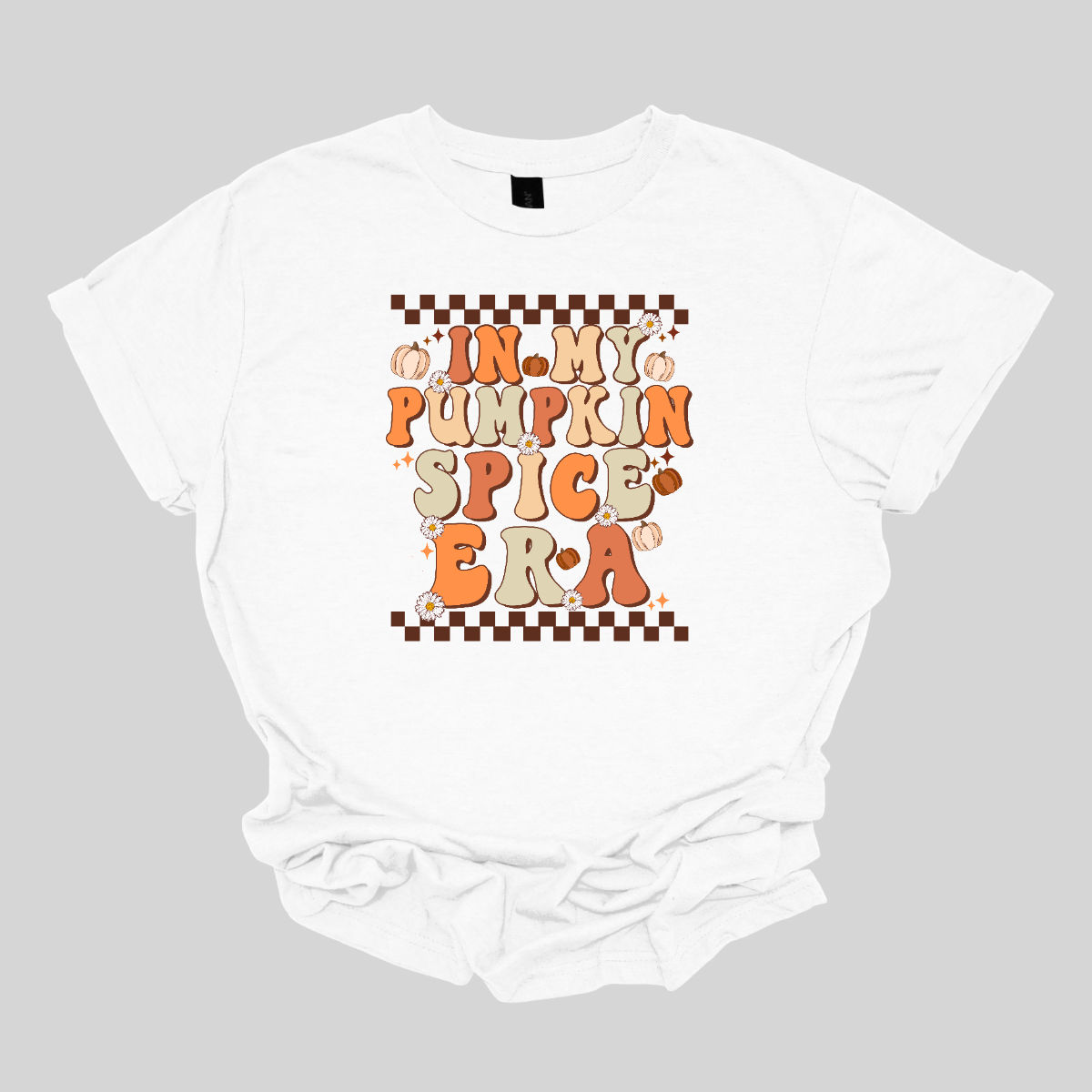 The t-shirt features a vibrant, retro-inspired design with the phrase "In My Pumpkin Spice Era" prominently displayed across the front. The text is rendered in a nostalgic, vintage-style font with an autumnal color palette. The letters are adorned in various shades of orange and yellow, with accents of green, evoking the warmth and richness of the fall season. Shop Gorgepusware.com