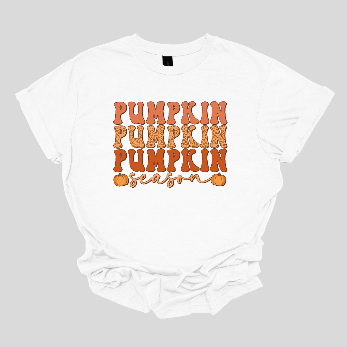 The t-shirt design features the phrase "Pumpkin Pumpkin Pumpkin Season" in a playful and eye-catching layout. At the top, the word "Pumpkin" is repeated three times, each instance stacked vertically. Each "Pumpkin" is rendered in a bold, attention-grabbing font, with each pumpkin in a progressively darker shade of orange. This gradient effect gives depth and dimension to the design, highlighting the seasonal theme. Shop Gorgeaousware.com