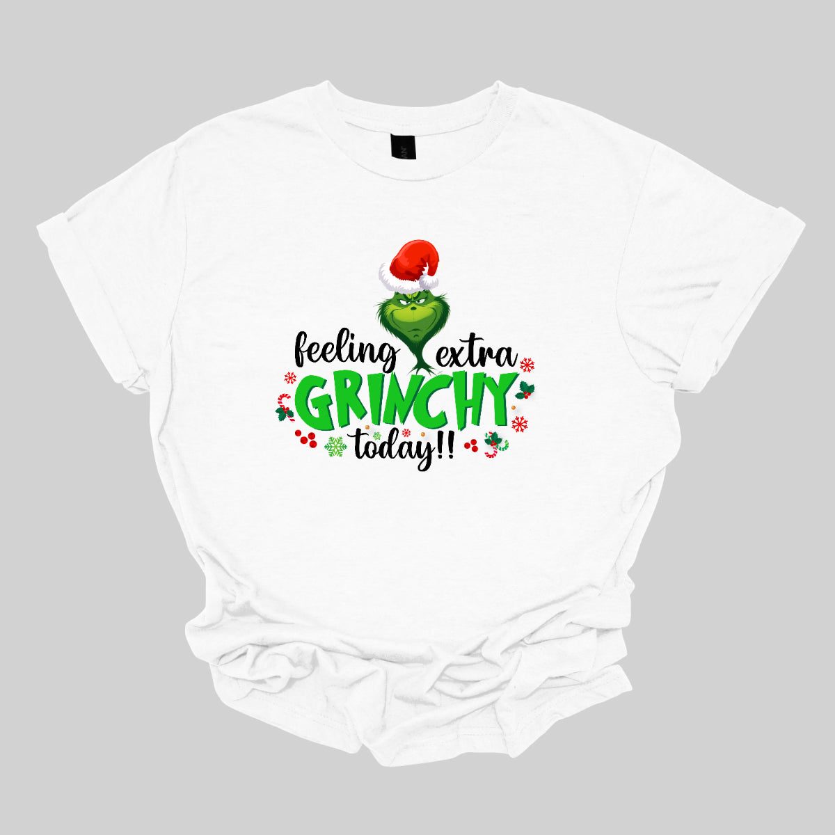 This T-shirt design exudes festive cheer and playful humor with its vibrant and eye-catching elements. The front of the shirt features the phrase, "Feeling extra grinchy today!!" prominently displayed in a fun and engaging. Shop Gorgeousware.com