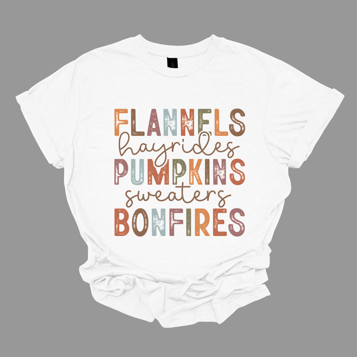 Get into the autumn spirit with our 'Fall Favorites' tee, featuring a dynamic design that celebrates all things cozy and festive! The shirt showcases the words 'Flannels,' 'Hayrides,' 'Pumpkins,' 'Sweaters,' and 'Bonfires,' each in a unique font style—from grunge print to elegant cursive. The vibrant, alternating colors add a playful touch to the design, capturing the essence of fall’s rich palette. Shop at Gorgeousware.com