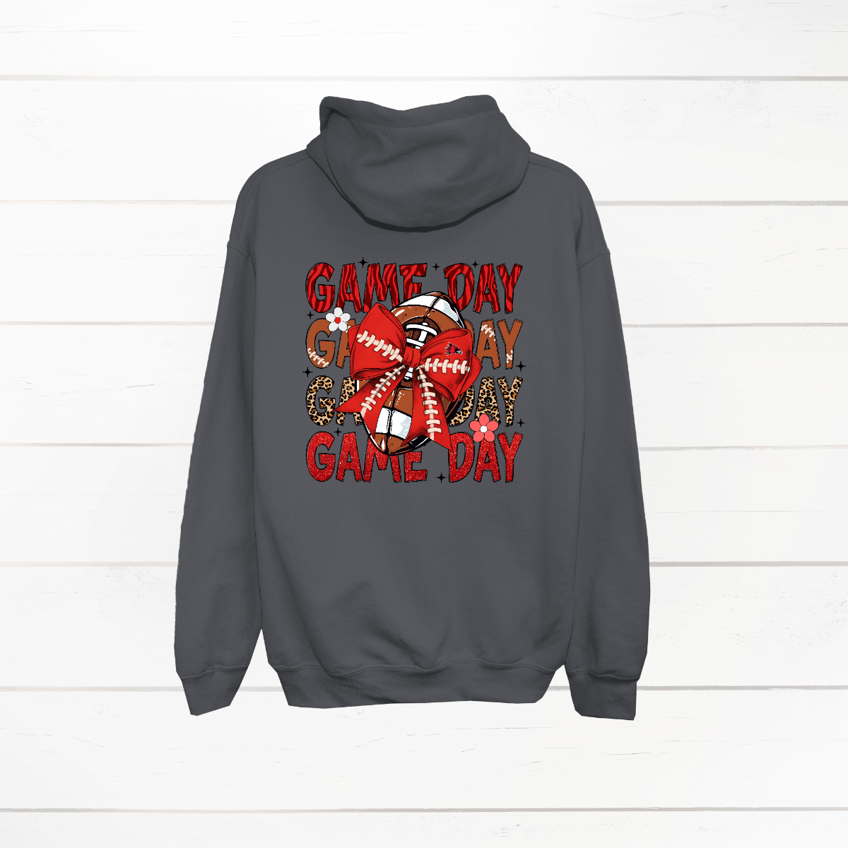 This bold SEMO shirt packs serious team spirit into every detail. The front has a ferocious Redhawk graphic paired with SEMO in bold white lettering over the left chest. The back has “Game Day” repeated in eye catching animal print and football-lace lettering. A football wrapped in a red bow steals the spotlight, complete with football-lace details and a small Redhawk perched on the bow. Go Redhawks! 
Shop at Gorgeousware.com today!
