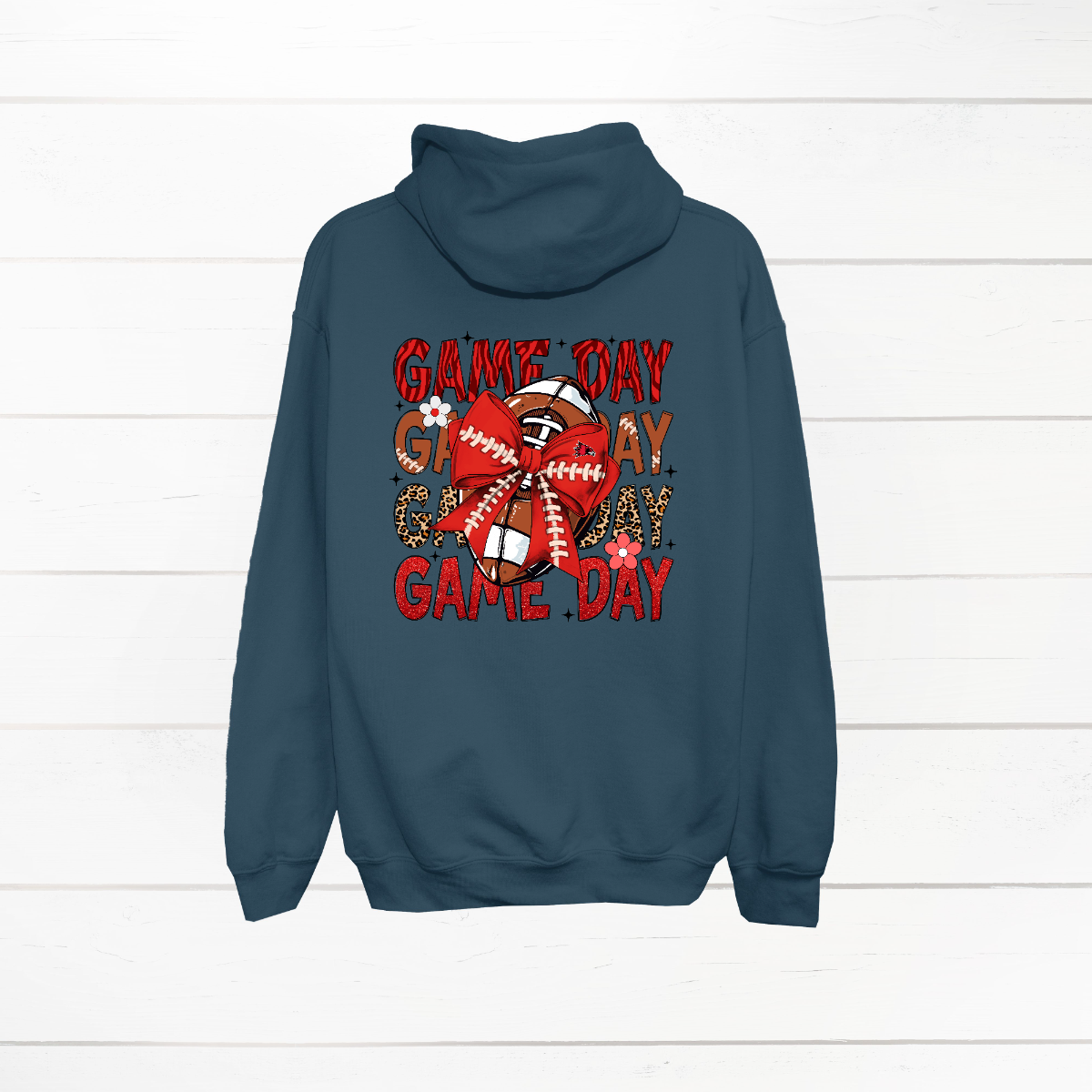 This bold SEMO shirt packs serious team spirit into every detail. The front has a ferocious Redhawk graphic paired with SEMO in bold white lettering over the left chest. The back has “Game Day” repeated in eye catching animal print and football-lace lettering. A football wrapped in a red bow steals the spotlight, complete with football-lace details and a small Redhawk perched on the bow. Go Redhawks! 
Shop at Gorgeousware.com today!
