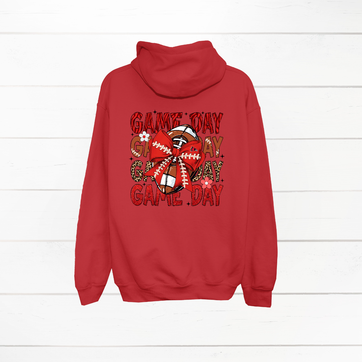 This bold SEMO shirt packs serious team spirit into every detail. The front has a ferocious Redhawk graphic paired with SEMO in bold white lettering over the left chest. The back has “Game Day” repeated in eye catching animal print and football-lace lettering. A football wrapped in a red bow steals the spotlight, complete with football-lace details and a small Redhawk perched on the bow. Go Redhawks! 
Shop at Gorgeousware.com today!
