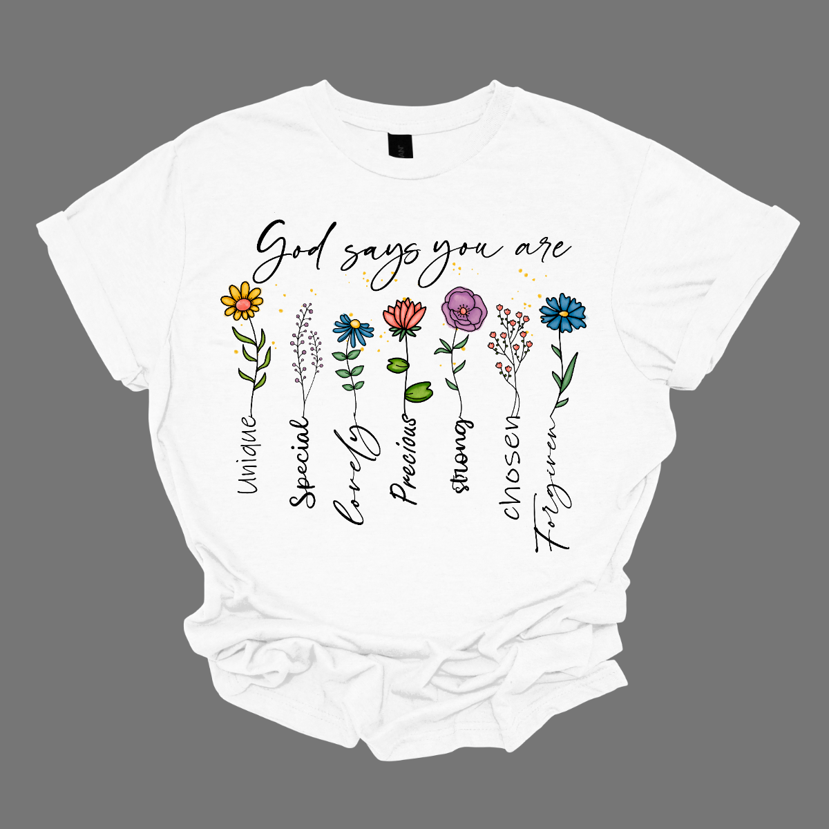 Divine Blooms T-shirt, a vibrant fusion of faith, affirmation, and floral beauty! Embrace the powerful message of divine love and empowerment with this stunning design, featuring colorful flowers blooming from the uplifting words: "God says you are unique, special, loved, precious, strong, chosen, forgiven."  Each stem of this floral masterpiece represents a facet of your divine identity, reminding you of your inherent worth and the boundless love that surrounds you. Shop now at Gorgeousware.com