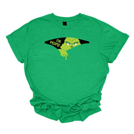 This T-shirt features a playful and eye-catching design centered around a cut-out illusion. The shirt showcases a dynamic cut-out effect, creating the appearance that a section of the fabric has been torn away. Through this cut-out, the Grinch is depicted in vivid, cartoonish detail, as though he’s emerging from the hole saying "Ew. People". Shop Gorgeousware.com