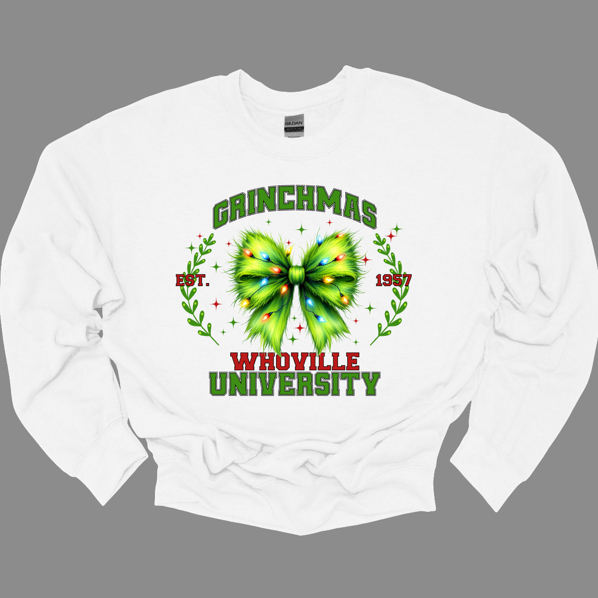 This festive apparel features the bold, collegiate-style lettering of "Grinch Whoville University" across the chest, giving it a spirited, school pride look. At the center of the design, a vibrant green Grinch-inspired croquet bow adds a playful touch, adorned with colorful Christmas lights, making the outfit perfect for the holiday season. Shop at Gorgeousware.com