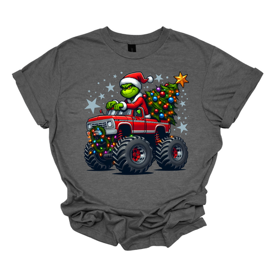 Gray t-shirt with a graphic of the grinch driving a truck that is hauling a Christmas tree, on a white background. Shop at Gorgeousware.com