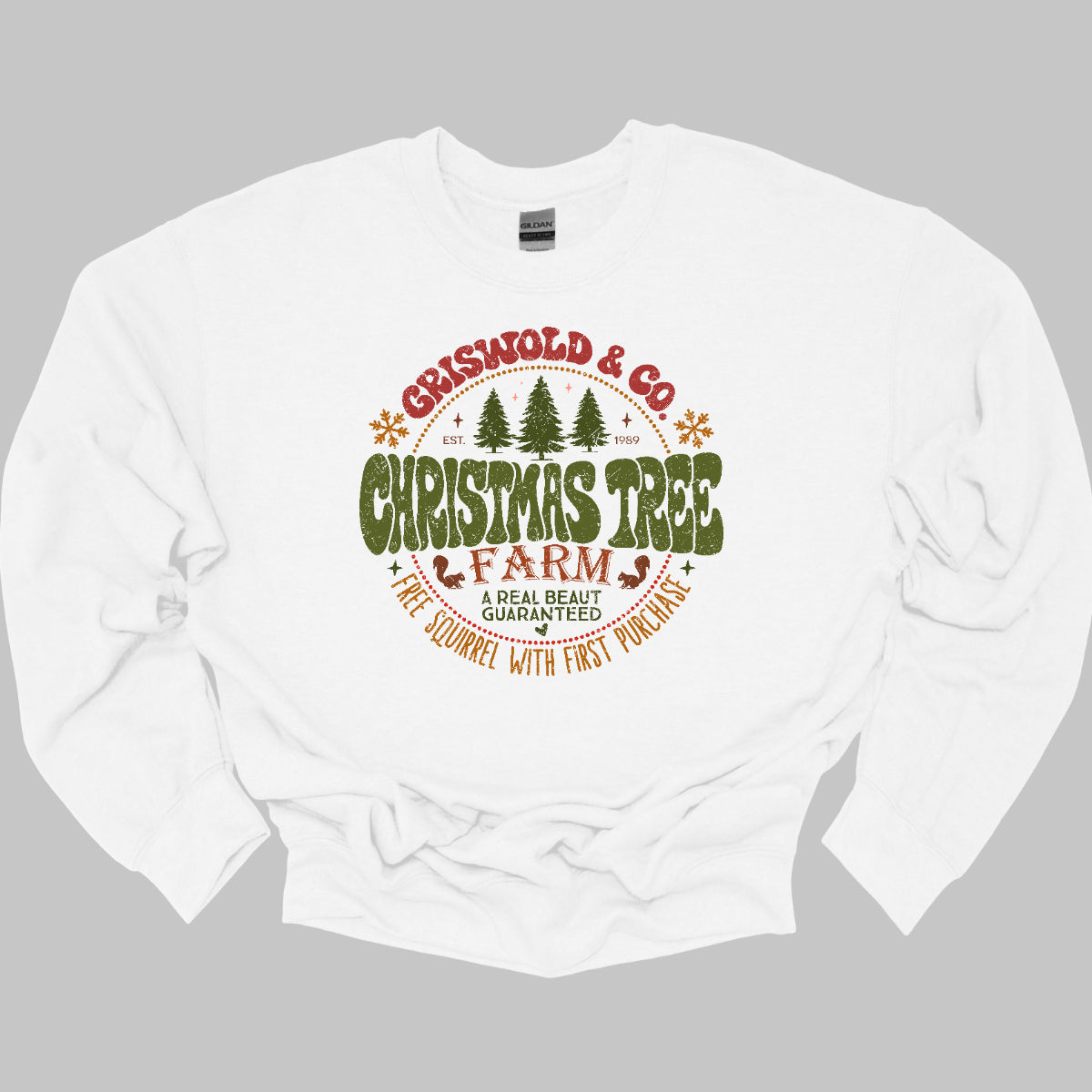 This festive t-shirt captures the spirit of holiday fun with a design inspired by classic Christmas cheer. The shirt features the words “Christmas Tree Farm” prominently displayed, with “Christmas Tree” in vibrant green bubble letters that pop with playful energy.Encircling this central text is “Griswold &amp; CO.,” giving it a nostalgic nod to the iconic family from holiday movie lore. Surrounding the main text are memorable quotes from the movie. Shop Gorgeousware.com