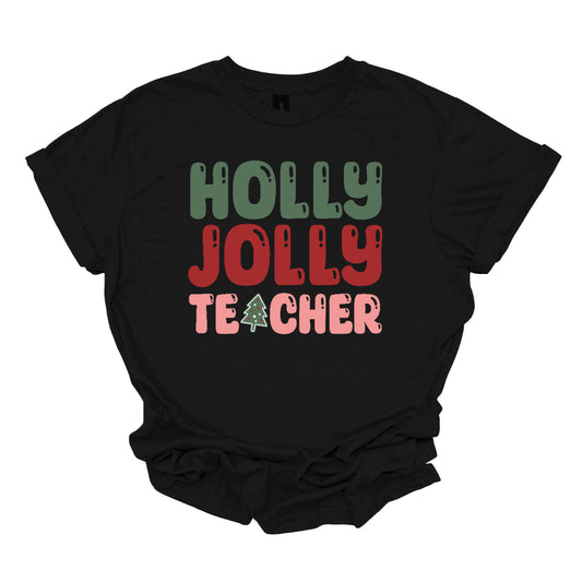 This festive t-shirt features the cheerful phrase "Holly Jolly Teacher" in a delightful bubbly font with fun cut-outs that add a playful touch. The word "Holly" is presented in a vibrant green, evoking the essence of holiday greenery, while "Jolly" pops in a bright red, radiating festive cheer. The word "Teacher" is in a cheerful pink, providing a lovely contrast. A whimsical twist comes with the letter "A" in "Teacher," which is creatively transformed into a charming Christmas tree. Shop Gorgeousware.com