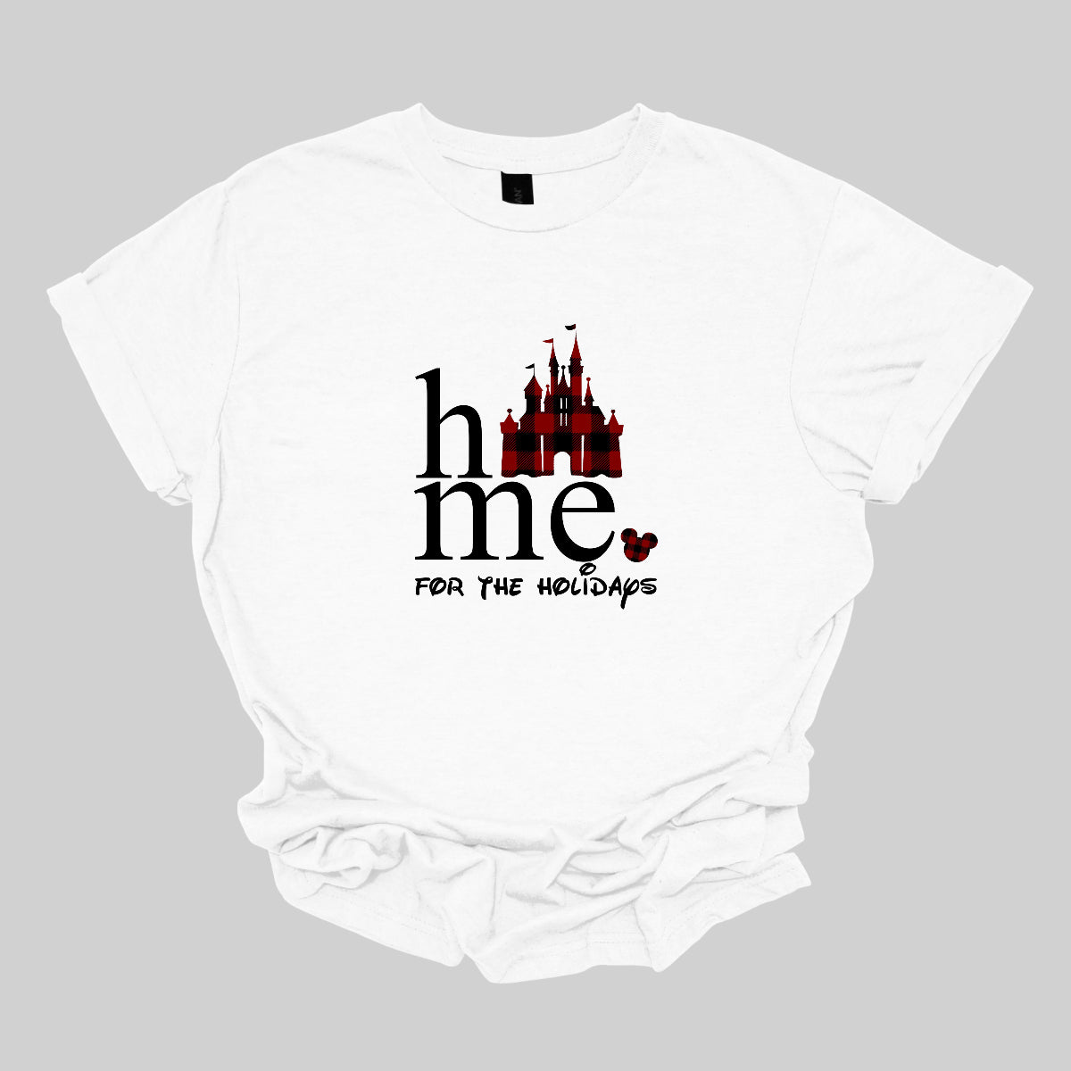 The t-shirt features the festive phrase "Home for the Holidays" with a delightful and whimsical touch. The word "Home" is showcased in a bold, playful font. In place of the "O" in "Home," there is a charming red and black checkerboard princess castle, adding a magical and eye-catching element to the design. Shop Gorgeousware.com