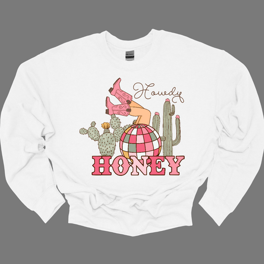 Introducing our "Howdy Honey" T-shirt – a dazzling and charming garment that brings together Western flair and a touch of disco glamour. This shirt features delightful elements such as cowgirl boots, cactuses, and a vibrant pink and white disco ball, creating a unique fusion of country and disco aesthetics. Adorning the T-shirt are stylish cowgirl boots, adding a Western charm, and cactuses that bring a hint of desert landscape. Shop at Gorgeousware.com