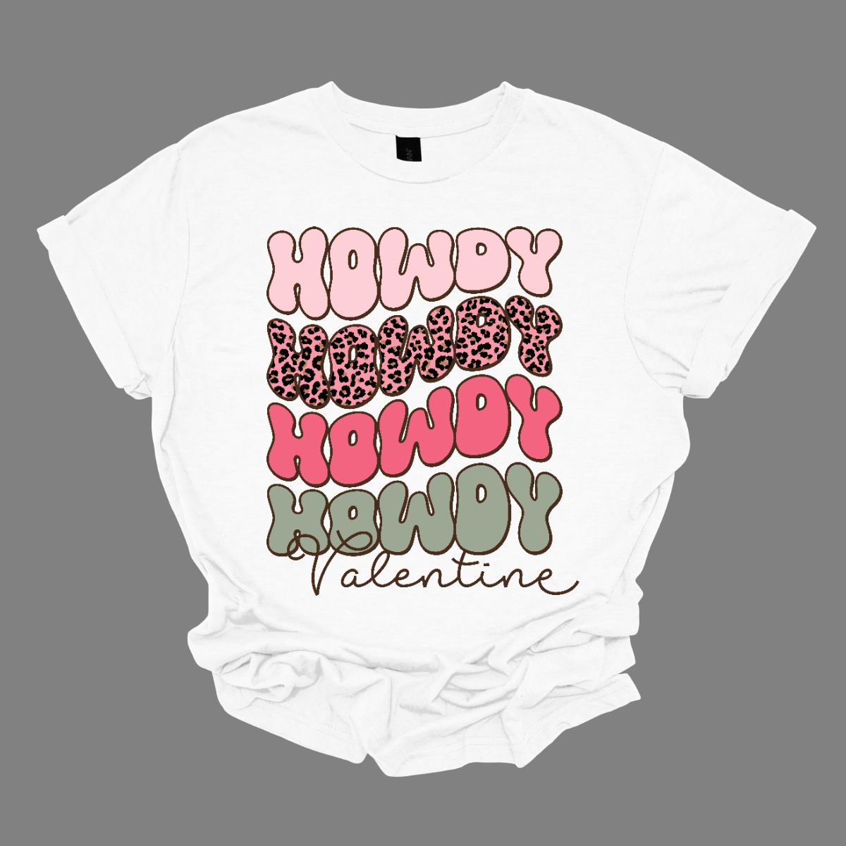 Introducing our "Howdy Valentine" T-shirt – a retro-inspired masterpiece that adds a touch of vintage charm to your Valentine's Day celebration. This shirt features a stylish retro font in soft pinks and sage colors, creating a delightful and nostalgic vibe perfect for expressing love with a Western twist.  The phrase "Howdy Valentine" is elegantly displayed in a retro font, evoking the classic aesthetics of bygone eras. Shop at Gorgeousware.com