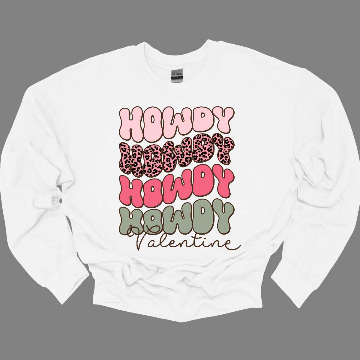 Introducing our "Howdy Valentine" T-shirt – a retro-inspired masterpiece that adds a touch of vintage charm to your Valentine's Day celebration. This shirt features a stylish retro font in soft pinks and sage colors, creating a delightful and nostalgic vibe perfect for expressing love with a Western twist.  The phrase "Howdy Valentine" is elegantly displayed in a retro font, evoking the classic aesthetics of bygone eras. Shop at Gorgeousware.com