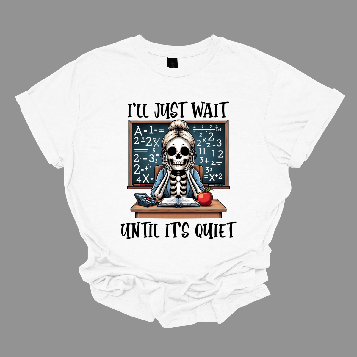 This T-shirt features a skeleton sitting at a cluttered desk, dressed in a cozy cardigan with a messy bun on top of its skull. The skeleton is leaning forward, resting its head on its bony hands as if exhausted or overwhelmed.  The shirt says, "I'll just wait until its quiet".  Shop at Gorgeousware.com 