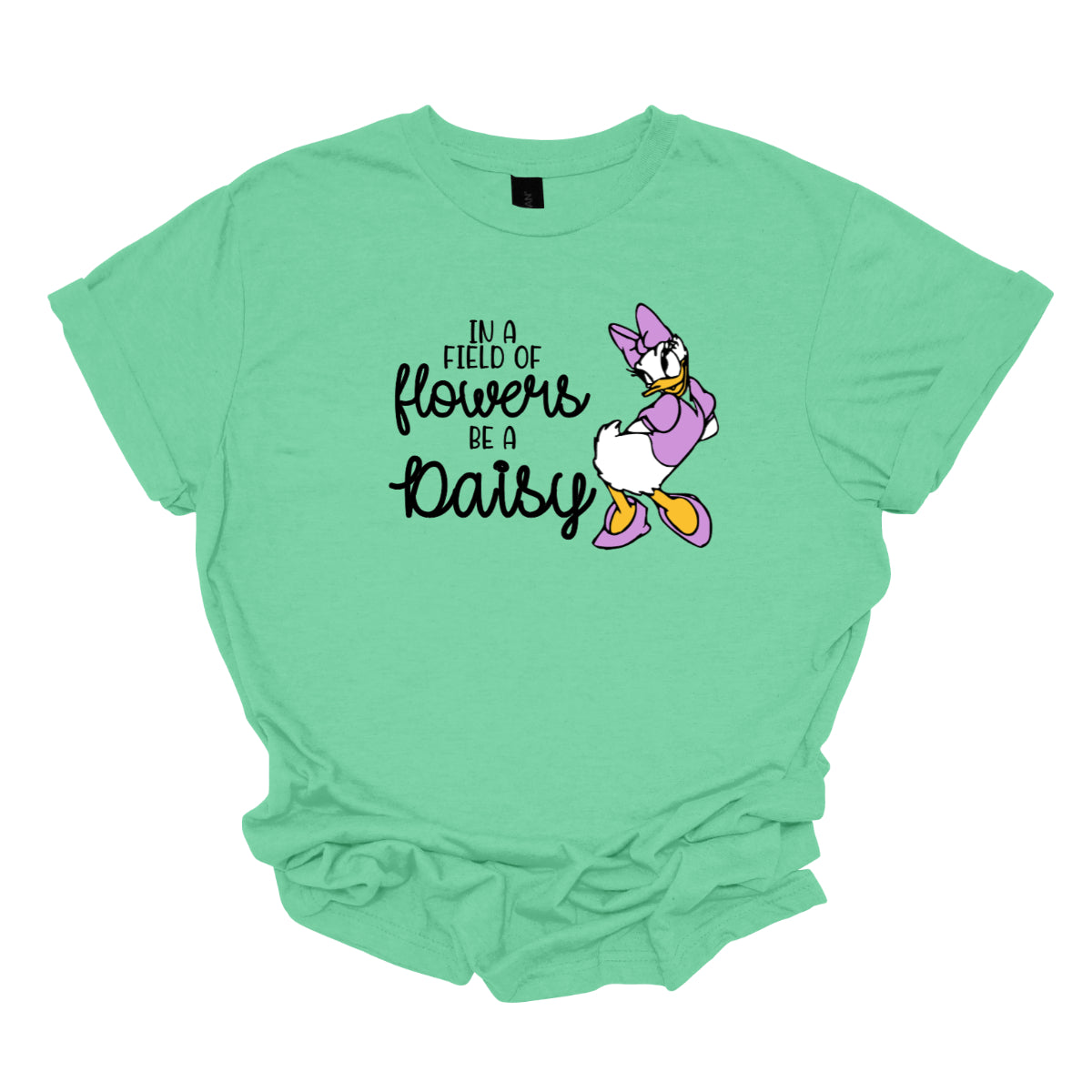 This t-shirt features an inspiring and charming design with the uplifting message: "In a Field of Flowers Be a Daisy." The phrase is styled with a delightful mix of fonts. The words "In a Field of" and "Be a" are written in a playful black font, bringing a touch of fun to the overall look. The words "Flowers" and "Daisy" are highlighted in a graceful black cursive font, adding a touch of elegance and flow. Next to the text, there’s a cute illustration of the cartoon character Daisy. Shop Gorgeousware.com