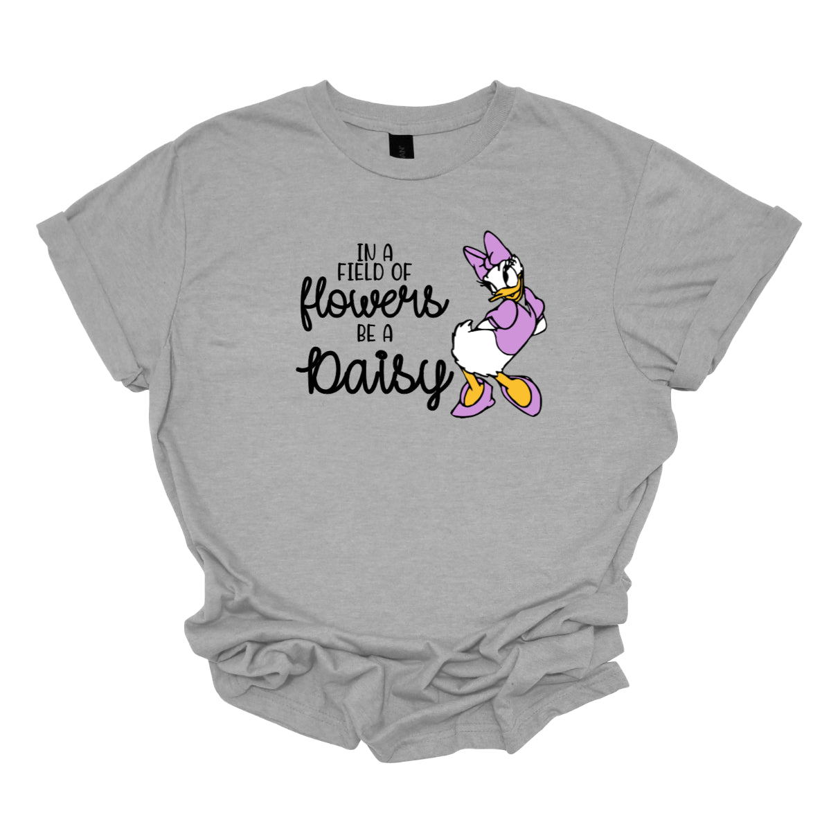 This t-shirt features an inspiring and charming design with the uplifting message: "In a Field of Flowers Be a Daisy." The phrase is styled with a delightful mix of fonts. The words "In a Field of" and "Be a" are written in a playful black font, bringing a touch of fun to the overall look. The words "Flowers" and "Daisy" are highlighted in a graceful black cursive font, adding a touch of elegance and flow. Next to the text, there’s a cute illustration of the cartoon character Daisy. Shop Gorgeousware.com