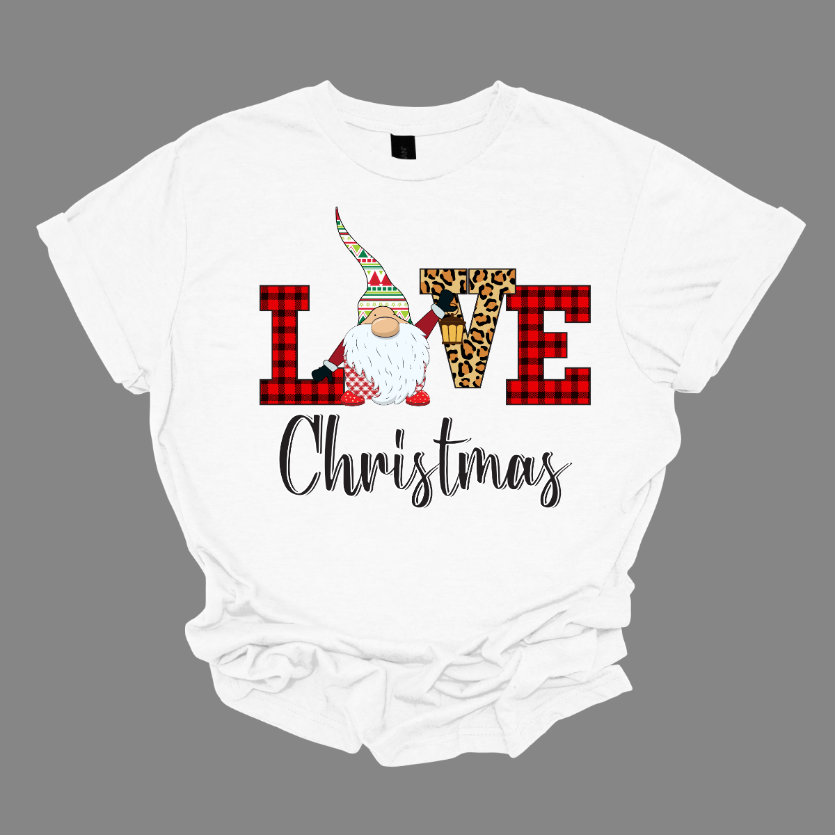 This charming t-shirt showcases the word "LOVE" in a festive and fun design. The letters "L" and "E" are styled in a classic red buffalo plaid, adding a cozy, rustic touch. The "V" pops with a bold cheetah print, bringing an unexpected and trendy flair to the design. The "O" is replaced by an adorable gnome, whose whimsical hat features a cheerful ugly sweater Christmas pattern in vibrant red, green, and white. Shop at Gorgeousware.com