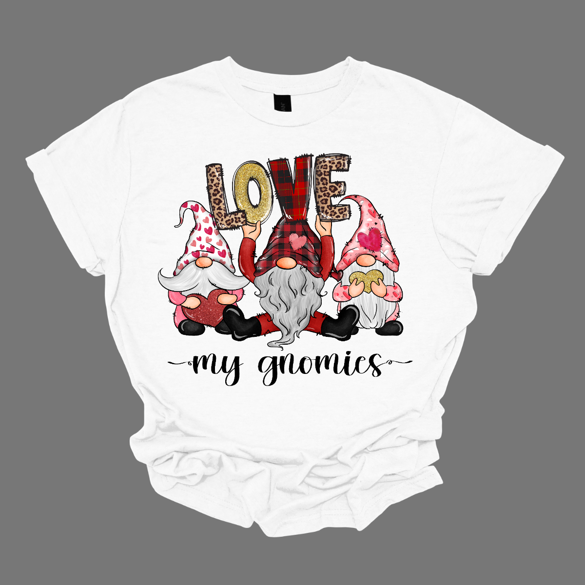 Introducing our "Love My Gnomies" T-shirt – a heartwarming and whimsical garment that celebrates the joy of friendship with three adorable gnomes holding up the word "love." This shirt is a delightful expression of love and camaraderie perfect for Valentine's Day. The design features three adorable gnomes, holding up the word "love," creating a cute and charming scene. Shop at Gorgeousware.com