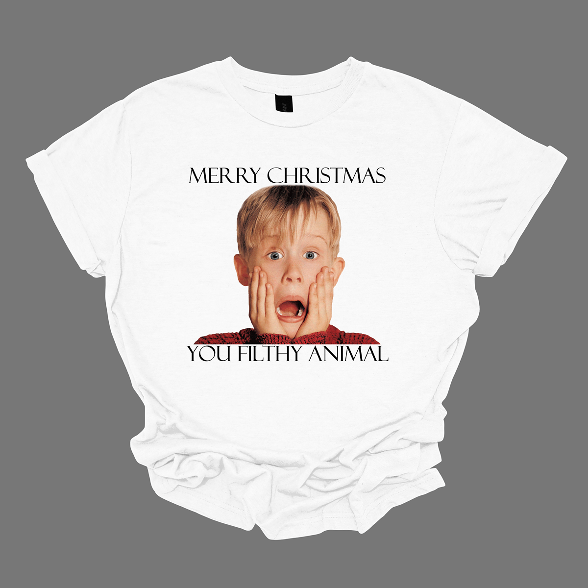 This fun and festive apparel features the iconic phrase "Merry Christmas You Filthy Animal" in bold, playful lettering, a memorable line from the Home Alone movie. The design also showcases the infamous face of Kevin McCallister, played by Macaulay Culkin, with his hands on his cheeks in a dramatic, surprised expression. Perfect for any Home Alone fan, this shirt or sweatshirt is ideal for spreading some holiday cheer and nostalgia.  Shop at Gorgeousware.com