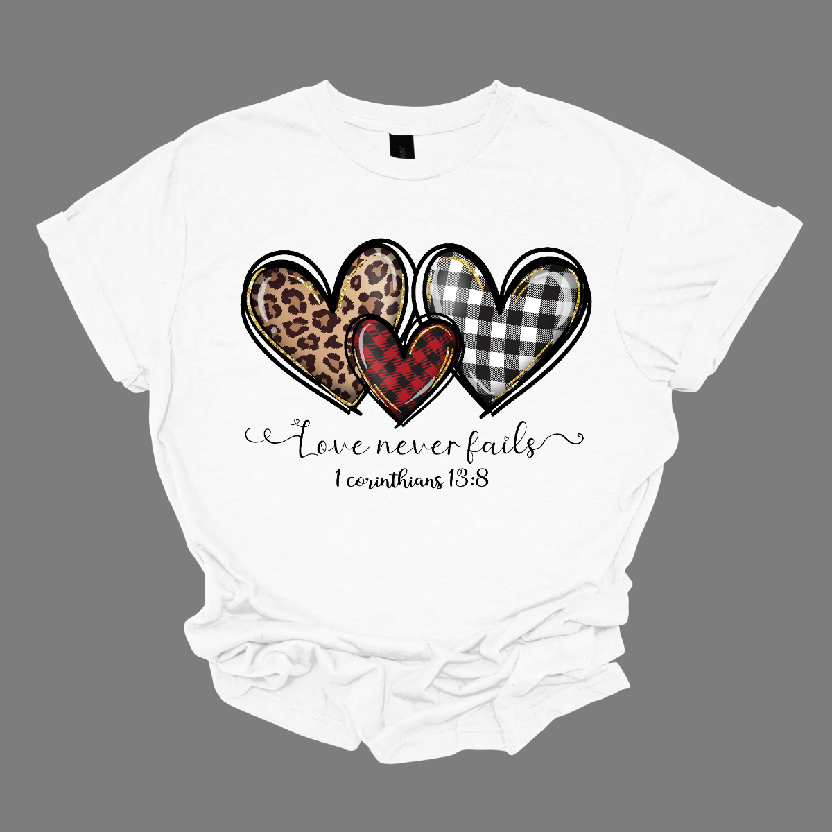 Introducing our "Love Never Fails - 1 Corinthians 13:8" T-shirt – a profound and heartwarming garment adorned with three adorable patterned hearts. This shirt carries a timeless message inspired by the scripture, emphasizing the enduring nature of love. The phrase "Love Never Fails - 1 Corinthians 13:8" is elegantly displayed, drawing inspiration from the Bible verse. Surrounding the sentiment are three cute hearts, each uniquely patterned with delightful designs. Shop at Gorgeousware.com