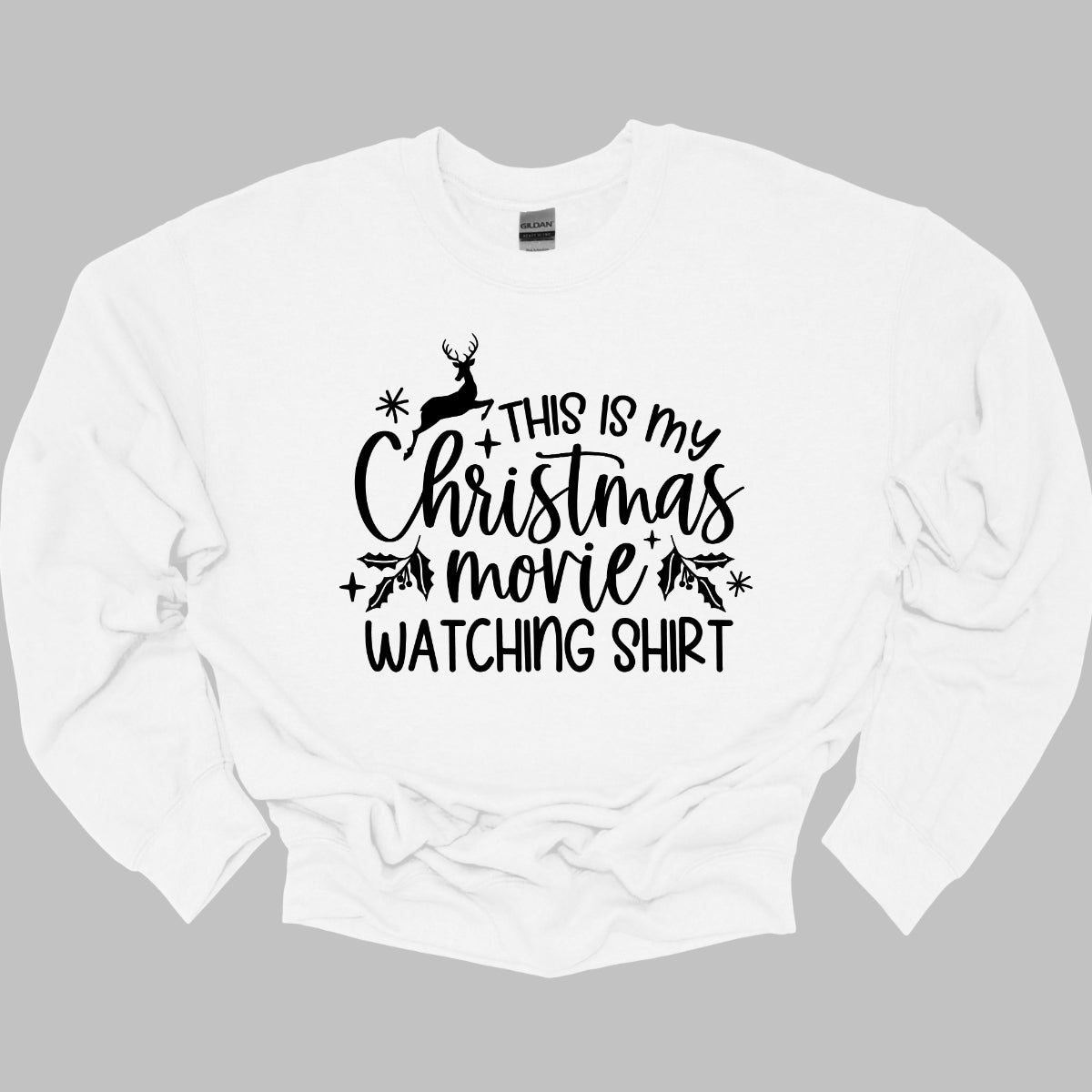 This cozy t-shirt features the playful phrase "This Is My Christmas Movie Watching Shirt" in a straightforward, easy-to-read font. The words "Christmas Movie" are beautifully highlighted in an elegant cursive font, adding a touch of festive flair. Shop Gorgeousware.com