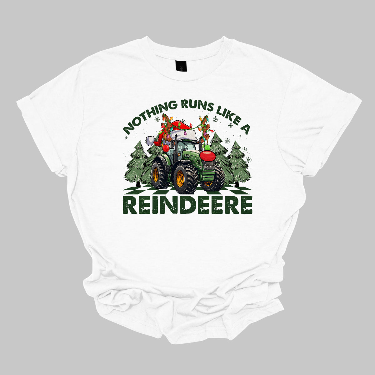 This playful t-shirt features the catchy phrase "Nothing runs like a reindeer" in bold black font, making a fun statement that’s perfect for the holiday season. At the center of the shirt, a charming John Deere tractor is decked out for Christmas: it sports a bright red nose, festive antlers, and a classic Santa hat, creating a delightful and humorous twist.&nbsp;The tractor is surrounded by whimsical Christmas trees, adding a cheerful backdrop that enhances the festive vibe. Shop Gorgeousware.com