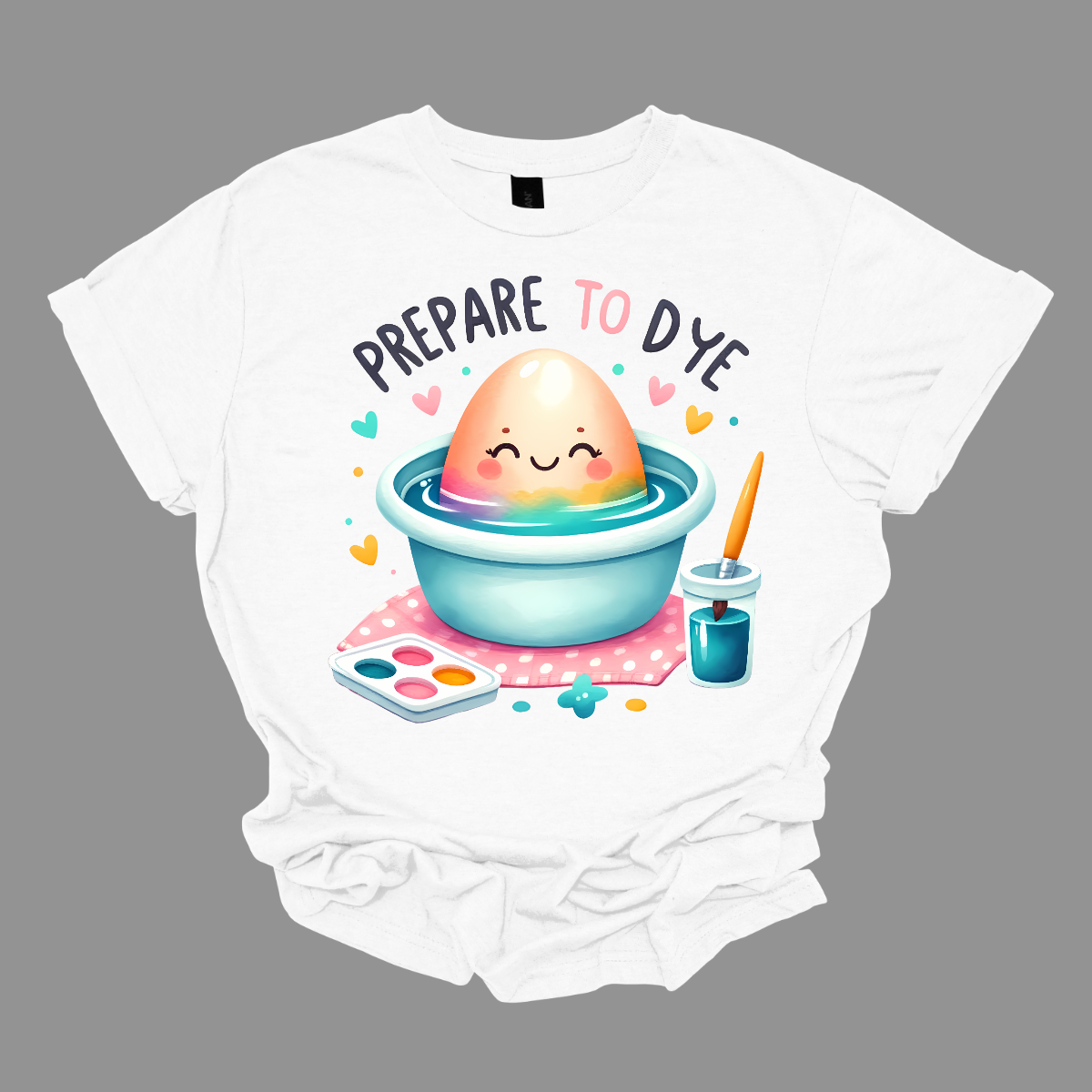 Get ready to add a splash of color to your Easter celebrations with our 'Prepare to Dye' T-shirt! This playful design features an Easter egg sitting in a bowl of dye alongside a paintbrush, capturing the excitement of decorating eggs for the holiday. Shop at Gorgeousware.com