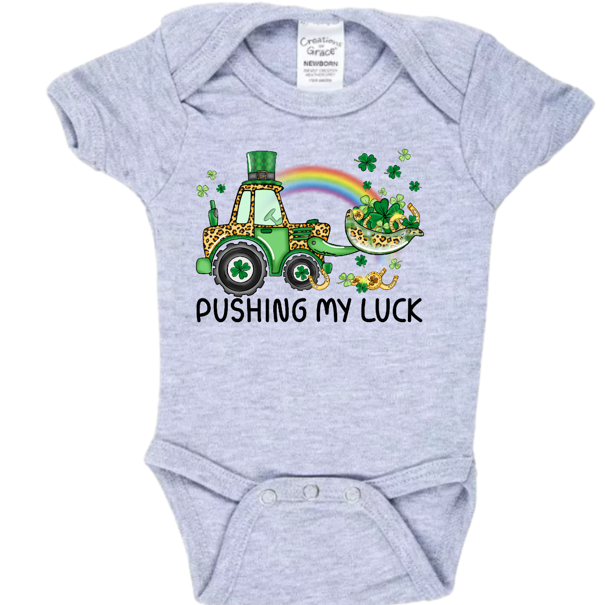 A playful and whimsical garment that captures the spirit of the holiday with a touch of fun. This shirt features a lively design with a tractor playfully shoveling a load of shamrocks, creating a unique and charming representation of pushing one's luck in a St. Patrick's Day context. The design showcases a tractor adorned with shamrocks, symbolizing the act of "pushing" luck in a light-hearted and festive manner. Shop at Gorgeousware.com