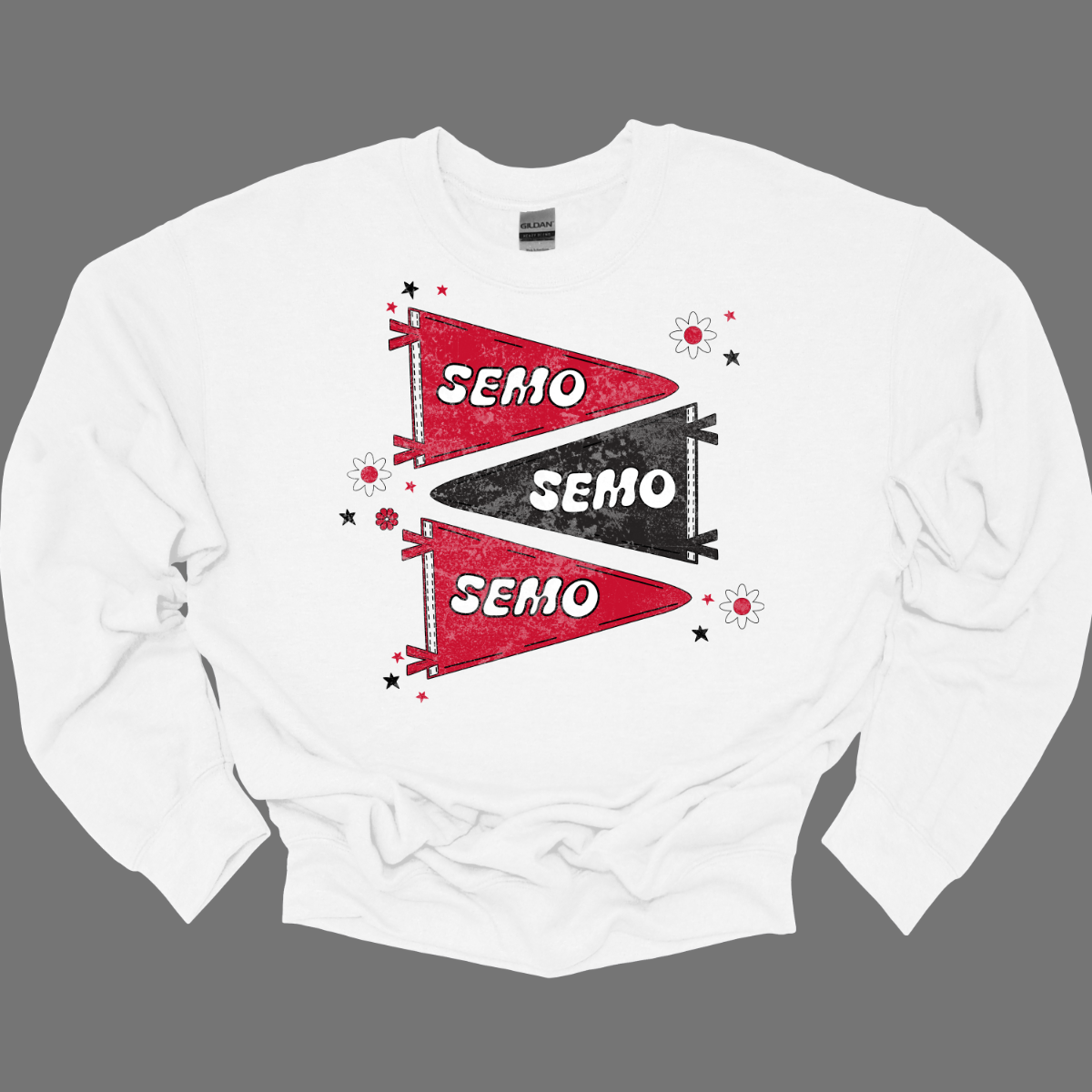 Show off your fully licensed Redhawk pride in youth sizes, with this retro-inspired SEMO design! Featuring three vintage-style pennants alternating in bold red and black, the layout gives a dynamic, old-school vibe. Each pennant is accented with groovy bubble lettering spelling “SEMO” in a playful wave, adding a fun twist to the classic look. Surrounding the pennants are a mix of retro red and black stars and flower motifs, bringing a nostalgic flair. 
Shop at Gorgeousware.com today!
