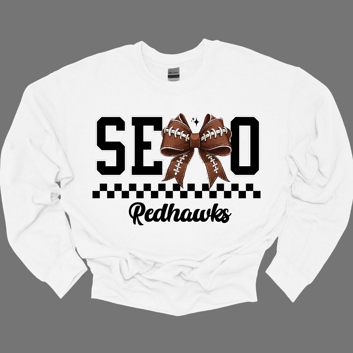 Gear up your Redhawk fan with our stylish youth SEMO apparel, available in short/ long sleeve, crewneck, and hoodie options! Featuring bold black SEMO lettering with a creative twist—the letter M is playfully replaced by a croquette football bow, adding a fun, sporty vibe. A sleek checkerboard underline ties the look together, while "Redhawks" is written in a stylish cursive script for the perfect finishing touch.
Shop at Gorgeousware.com today!
