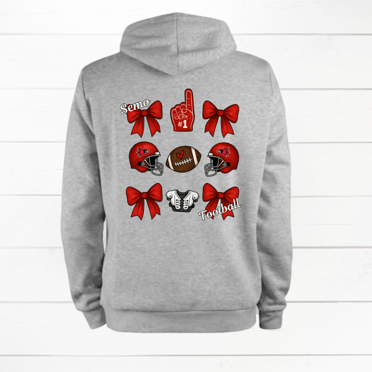 This SEMO Football Bow Grid design is available in youth sizes across short sleeve, long sleeve, crewneck, and hoodie options.
Front Design: A chic red croquette bow sits on the upper left chest, accented with bold white “SEMO” lettering.
Back Design: A playful grid layout showcases an exciting mix of Redhawk game-day icons—red croquette bows, SEMO football helmets, sturdy shoulder pads, and the classic #1 foam hand—all celebrating SEMO’s winning spirit.
Shop at Gorgeousware.com today!
