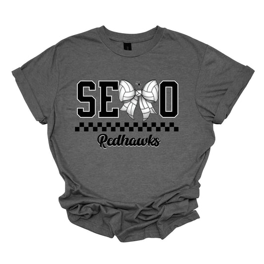 The apparel design features the word "SEMO" in a bold collegiate font, with a unique twist on the letter "M." Instead of the standard "M," a bow with a volleyball pattern is used, making it a distinctive and sporty element. Beneath "SEMO," a striking black checkerboard pattern runs horizontally across the garment, adding visual contrast and energy.  Shop at Gorgeousware.com