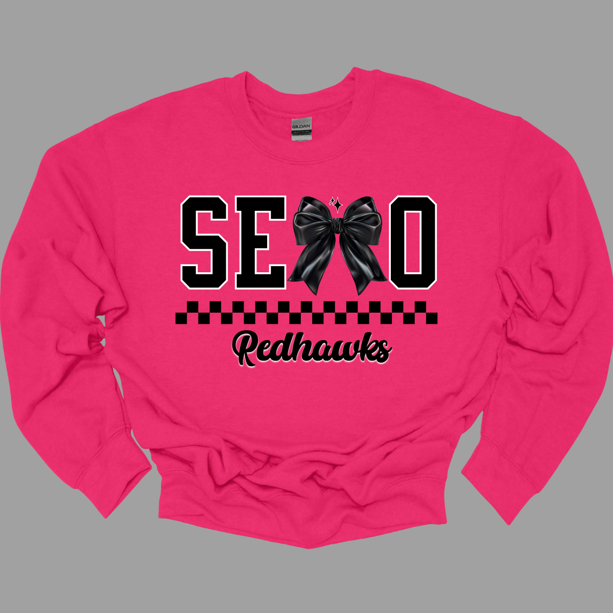 Show off your SEMO pride in style with this trendy creneck and hoodie! Featuring the bold letters "SEMO," where the "M" is cleverly replaced by a stylish black croquette bow, this shirt adds a unique twist to your wardrobe. Underneath, a playful checkerboard stripe adds a fun touch, while "Redhawks" is elegantly written in a cute cursive font, bringing a touch of flair. Shop at Gorgeousware.com