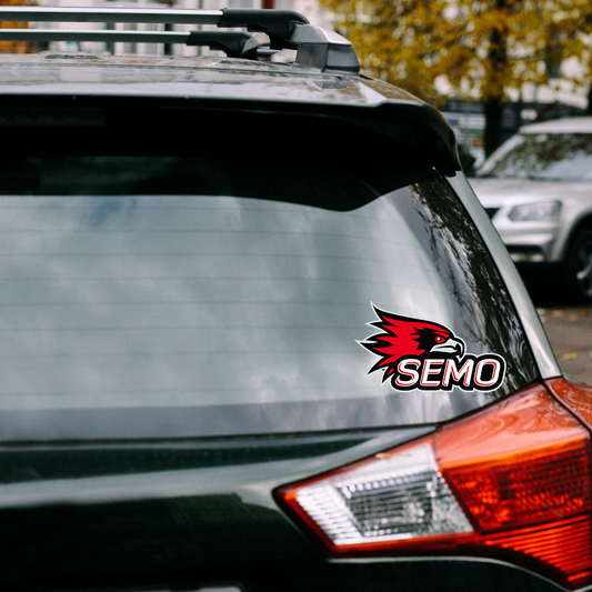 Show off your school spirit with this dynamic car window decal featuring the iconic Redhawk mascot! The bold design includes "SEMO" in fun, eye-catching bubble letters beneath the mascot, making it a standout addition to any vehicle. Measuring 5x5.85 inches, this decal is perfect for personalizing your car while proudly representing your team on the go. Easy to apply and durable, it’s a must-have for any SEMO fan! Shop at Gorgeousware.com