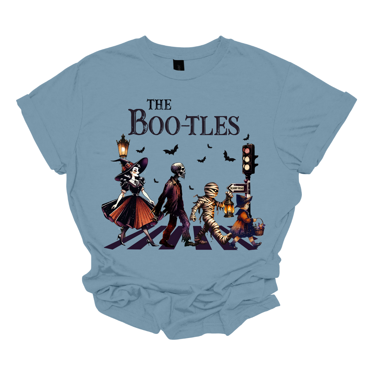 Step into a spooky twist on a classic with our 'Boot-les' tee! This Halloween-themed shirt takes inspiration from the iconic Abbey Road album cover and reimagines it with a creepy-cool lineup of Halloween characters. Picture this: a mischievous witch, a spooky skeleton, a creepy mummy, and a charming little witch, all crossing a spectral road in style.  Shop at Gorgeousware.com