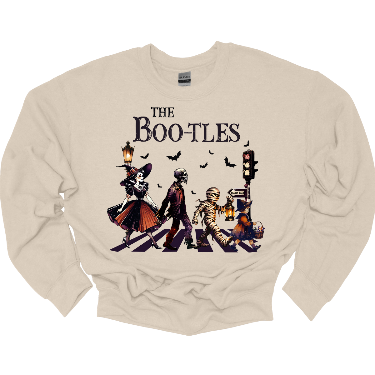 Step into a spooky twist on a classic with our 'Boot-les' tee! This Halloween-themed shirt takes inspiration from the iconic Abbey Road album cover and reimagines it with a creepy-cool lineup of Halloween characters. Picture this: a mischievous witch, a spooky skeleton, a creepy mummy, and a charming little witch, all crossing a spectral road in style.  Shop at Gorgeousware.com