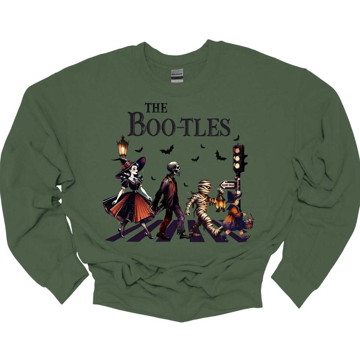 Step into a spooky twist on a classic with our 'Boot-les' tee! This Halloween-themed shirt takes inspiration from the iconic Abbey Road album cover and reimagines it with a creepy-cool lineup of Halloween characters. Picture this: a mischievous witch, a spooky skeleton, a creepy mummy, and a charming little witch, all crossing a spectral road in style.  Shop at Gorgeousware.com