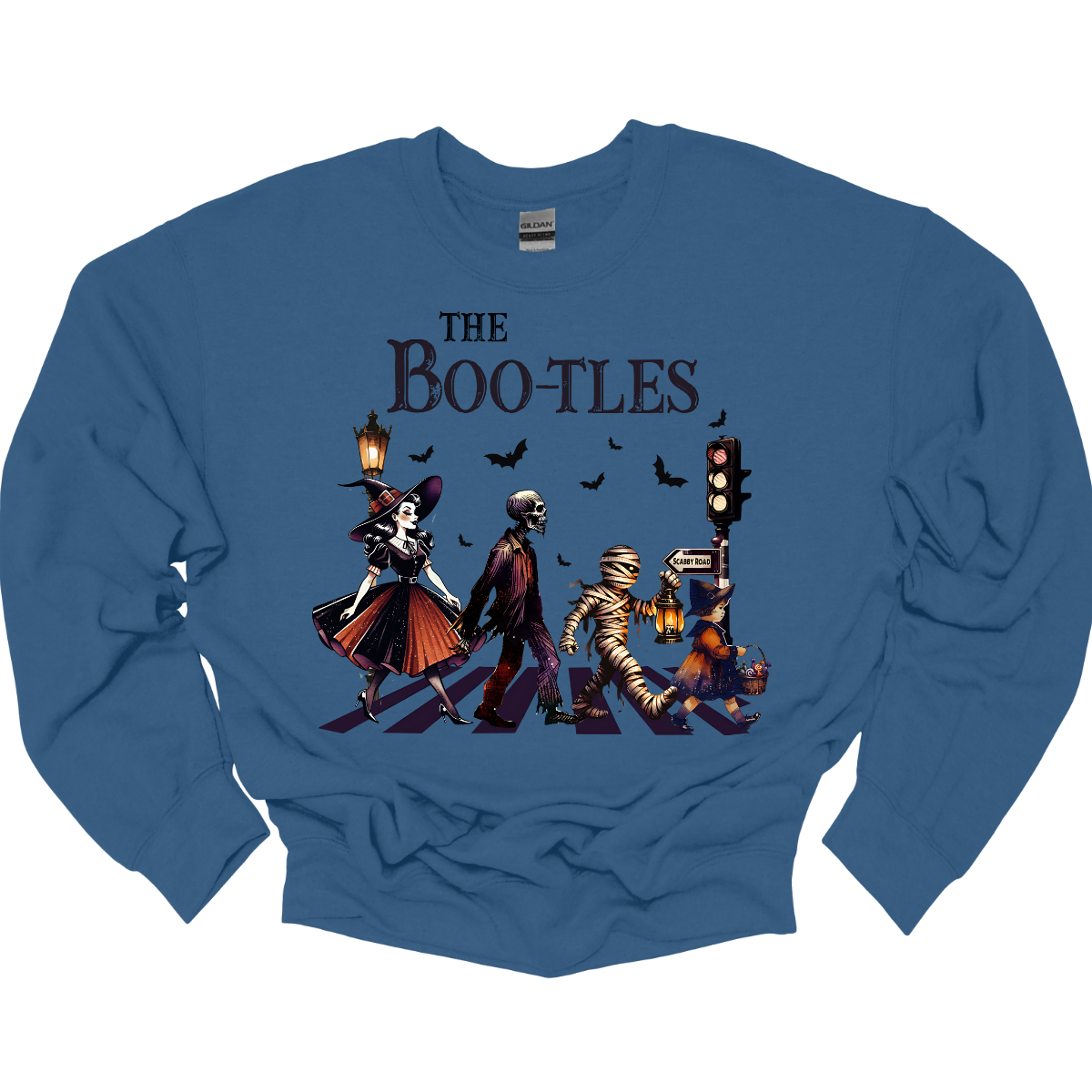 Step into a spooky twist on a classic with our 'Boot-les' tee! This Halloween-themed shirt takes inspiration from the iconic Abbey Road album cover and reimagines it with a creepy-cool lineup of Halloween characters. Picture this: a mischievous witch, a spooky skeleton, a creepy mummy, and a charming little witch, all crossing a spectral road in style.  Shop at Gorgeousware.com