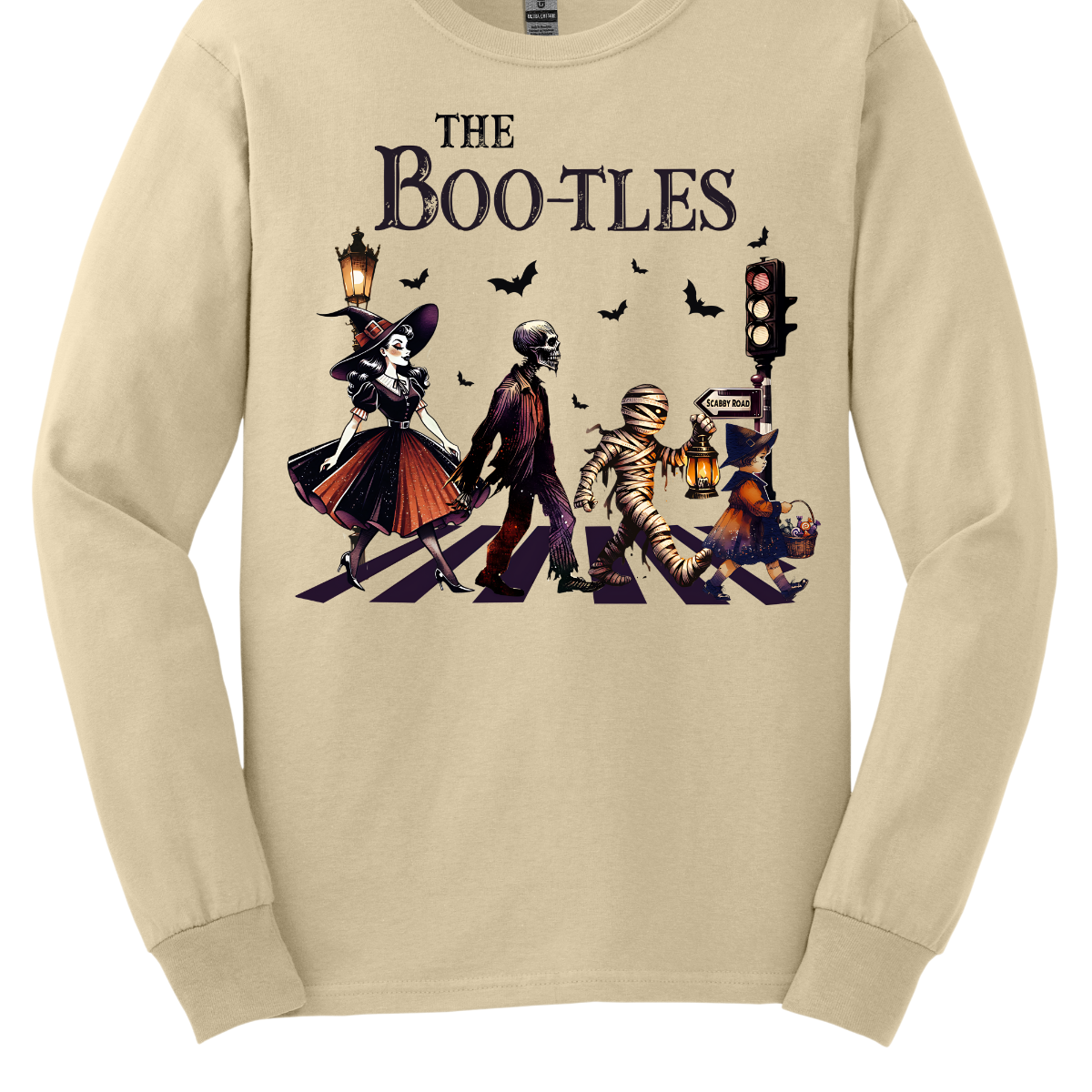 Step into a spooky twist on a classic with our 'Boot-les' tee! This Halloween-themed shirt takes inspiration from the iconic Abbey Road album cover and reimagines it with a creepy-cool lineup of Halloween characters. Picture this: a mischievous witch, a spooky skeleton, a creepy mummy, and a charming little witch, all crossing a spectral road in style.  Shop at Gorgeousware.com