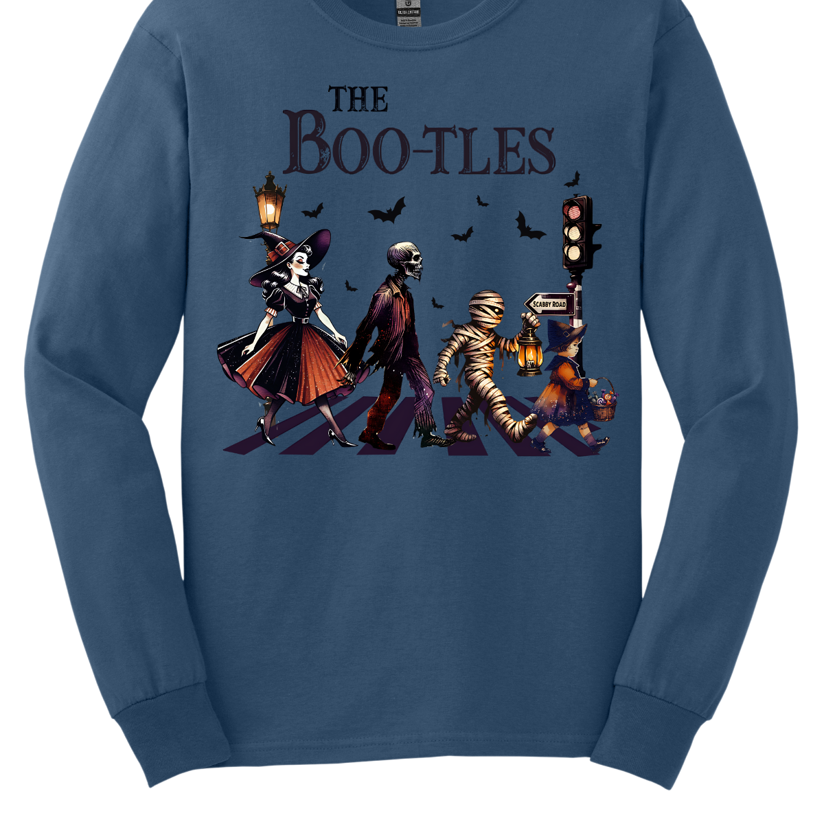 Step into a spooky twist on a classic with our 'Boot-les' tee! This Halloween-themed shirt takes inspiration from the iconic Abbey Road album cover and reimagines it with a creepy-cool lineup of Halloween characters. Picture this: a mischievous witch, a spooky skeleton, a creepy mummy, and a charming little witch, all crossing a spectral road in style.  Shop at Gorgeousware.com