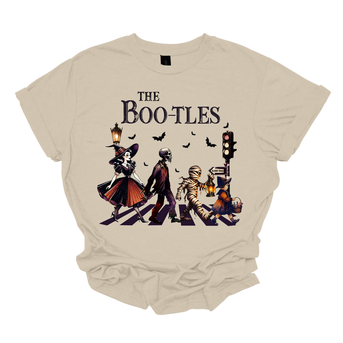 Step into a spooky twist on a classic with our 'Boot-les' tee! This Halloween-themed shirt takes inspiration from the iconic Abbey Road album cover and reimagines it with a creepy-cool lineup of Halloween characters. Picture this: a mischievous witch, a spooky skeleton, a creepy mummy, and a charming little witch, all crossing a spectral road in style.  Shop at Gorgeousware.com