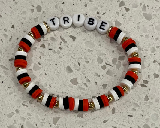 Show your team spirit with the Jackson Tribe Baseball bracelet! This eye-catching accessory features a bold design of alternating red, black, and white colors, symbolizing the passion and energy of the Jackson Tribe. Each color segment is separated by a striking gold-colored ball, adding a touch of flair to the overall look. At the center, the word "TRIBE" is proudly displayed, making it clear where your loyalties lie. Perfect for game days or everyday wear. Shop at Gorgeousware.com