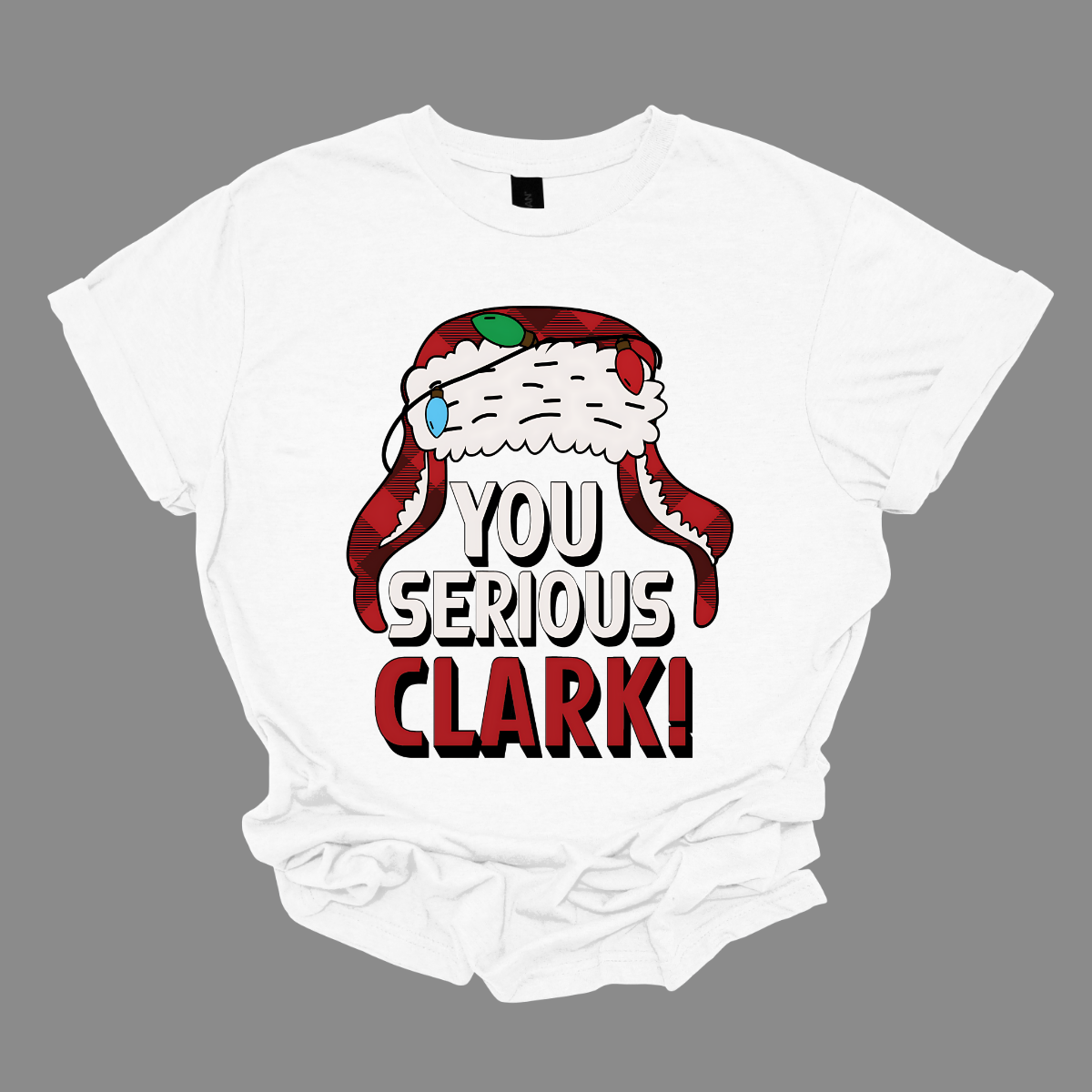 Get ready to light up the holiday season with a dose of classic comedy! Our “You Serious, Clark!” t-shirt pays homage to the unforgettable line from National Lampoon’s Christmas Vacation. Featuring a bold, eye-catching graphic of Clark Griswold’s iconic winter trapper hat, adorned with colorful Christmas lights, this shirt is perfect for any fan of the movie. Shop at Gorgeousware.com